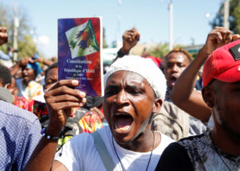 Manifestation en Haïti – Des citoyens haïtiens brandissent des pancartes pour revendiquer leurs droits face à la crise sociale et politique.